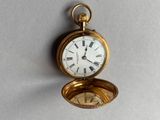 une montre de poche en or avec des chiffres romains