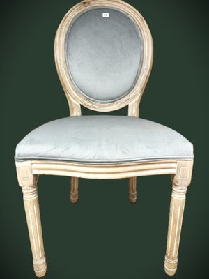 une image représentant une chaise blanche sur laquelle est posé un coussin bleu