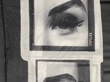 a black and white photo of a pillow with a picture of a woman ' s eyes on it