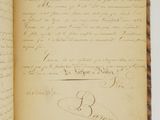 an open book with a handwritten page on it sitting on a table