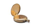 a gold pocket watch sitting on a white surface