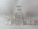 Des bouteilles et des verres sont alignés sur une surface blanche