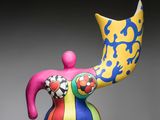 a colorful statue of a woman with a hat on her head