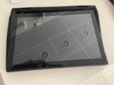 une tablette posée sur une table, à côté d'une tasse de café