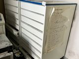a refrigerator that has a bunch of drawers on top of it