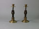 pair of antique brass candlesticks with figures on each of them