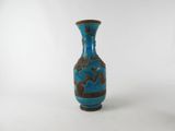 a small blue vase with a brown decoration on it