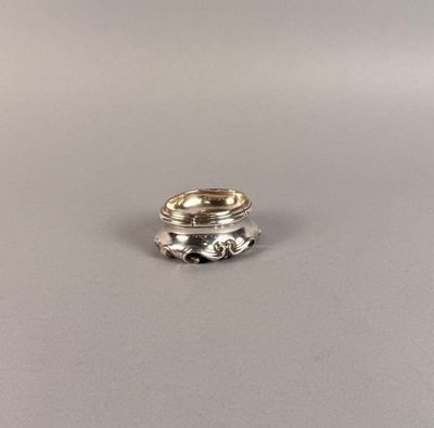 un gros plan d'une bague en argent posée sur une surface grise