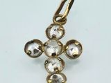a close up of a gold cross with clear stones on it