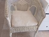 une chaise en osier avec un coussin posé dessus dans la cuisine