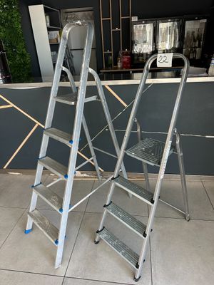 two ladders sitting on top of a tiled floor next to a counter
