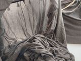 un lit recouvert d'un couvre-lit gris dans une chambre