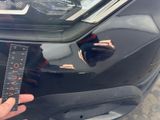 a person holding a ruler in front of a car