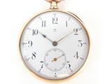 a close up of a pocket watch on a white surface