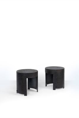 two black stools sitting next to each other on a white surface