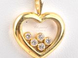 an image of a heart shaped pendant with three diamonds in it