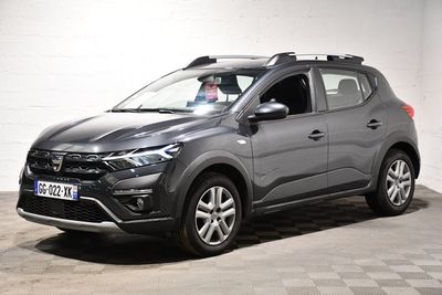 Le SUV gris est garé dans un garage dont le sol est en damier.