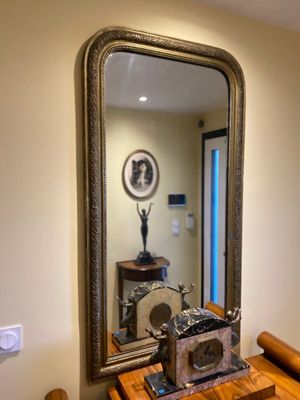 a mirror on the wall above a table with a clock on it