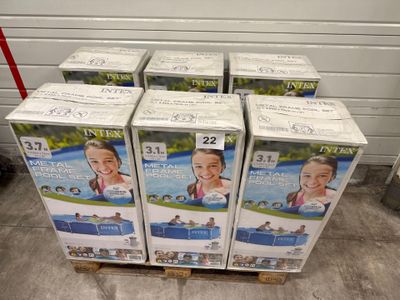 six cartons de couches pour bébés empilés sur une palette dans un entrepôt