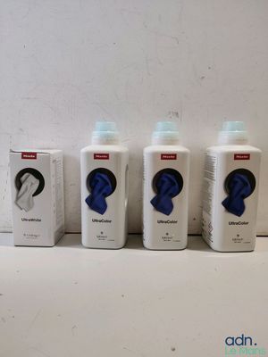 quatre flacons de savon posés sur un plan de travail, à côté d'une boîte de savon