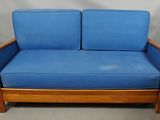 an image of a blue couch with a wooden frame and blue cushions