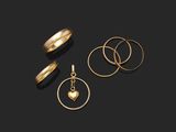 three gold rings and a heart pendant on a black background