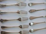 a lot of forks and spoons that are on the table