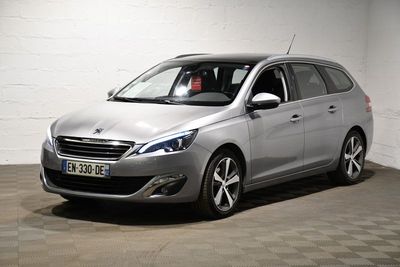 La voiture argentée est garée dans un garage dont le sol est à damier.