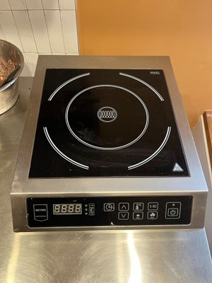 un plan de travail en acier inoxydable surmonté d'un brûleur noir