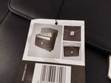 a black wallet with a barcode on it next to a cell phone