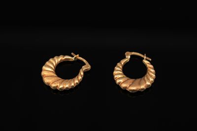 une paire de boucles d'oreilles en or sur fond noir