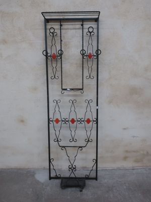 a black iron gate with red flowers on it