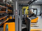a forklift in a warehouse with pallets on the floor