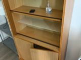 une bibliothèque en bois à deux étagères et un ordinateur portable posé par terre