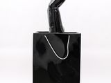 sculpture of a woman ' s hand holding a shopping bag on a white background