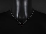 un gros plan sur un mannequin portant un collier orné d'un diamant blanc