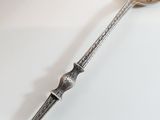a silver spoon with a spoon handle on a table