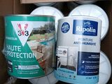 three cans of paint and a can of paint in a cardboard box