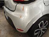 a white car that has been dented and is parked in a garage