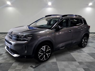 un 4x4 gris garé dans une pièce au sol en damier