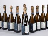 six bouteilles de vin sont alignées sur une table