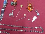 a lot of jewelry on a table with a red table cloth