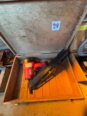 une boîte contenant un pistolet à clous et un pistolet à clous