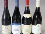 quatre bouteilles de vin sont alignées sur une table