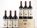 six bottles of wine in a cardboard box on a table