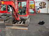une pelleteuse rouge qui se trouve à l'intérieur d'un bâtiment