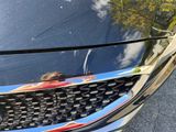 a close up of a car ' s grille with a reflection of a person on it