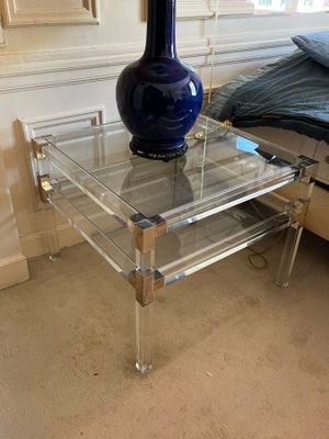 a glass table with a blue vase on it