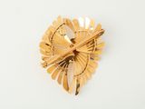 an image of a gold brooch or pin with a leaf design