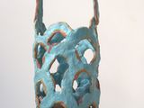 a sculpture of a basket on a stand on a table